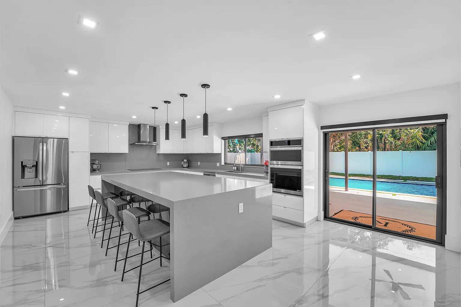 Cocina de chef con isla custom de gran formato y vista a la piscina