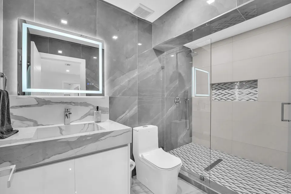Baño moderno con espejo LED y ducha walk-in