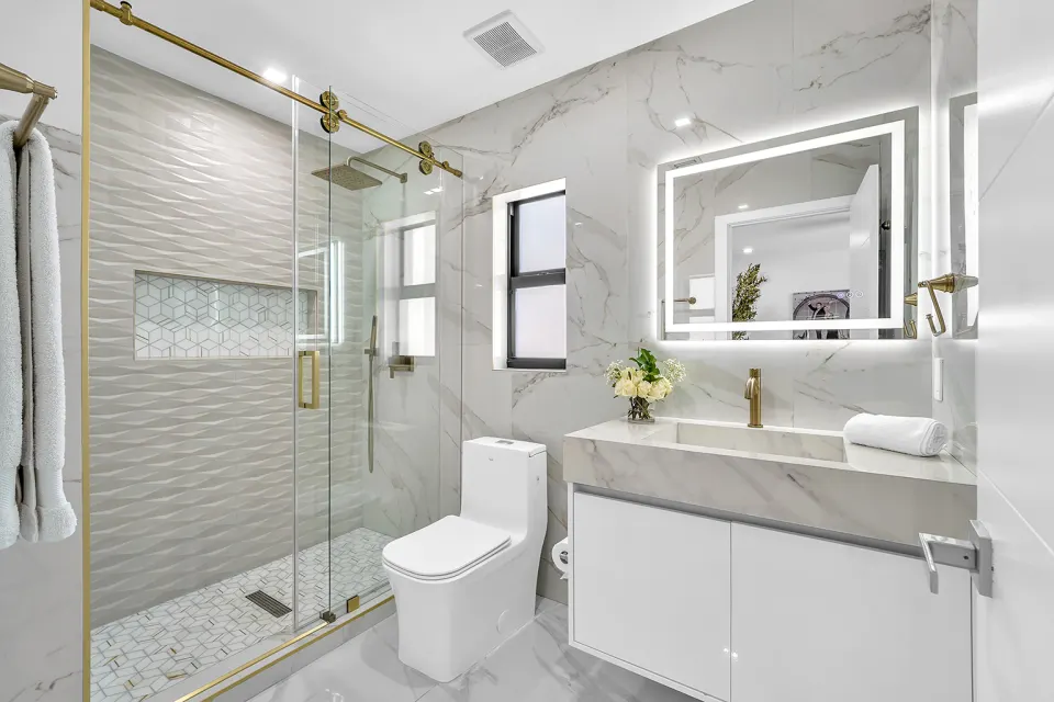 Baño tipo spa con griferías doradas y mármol