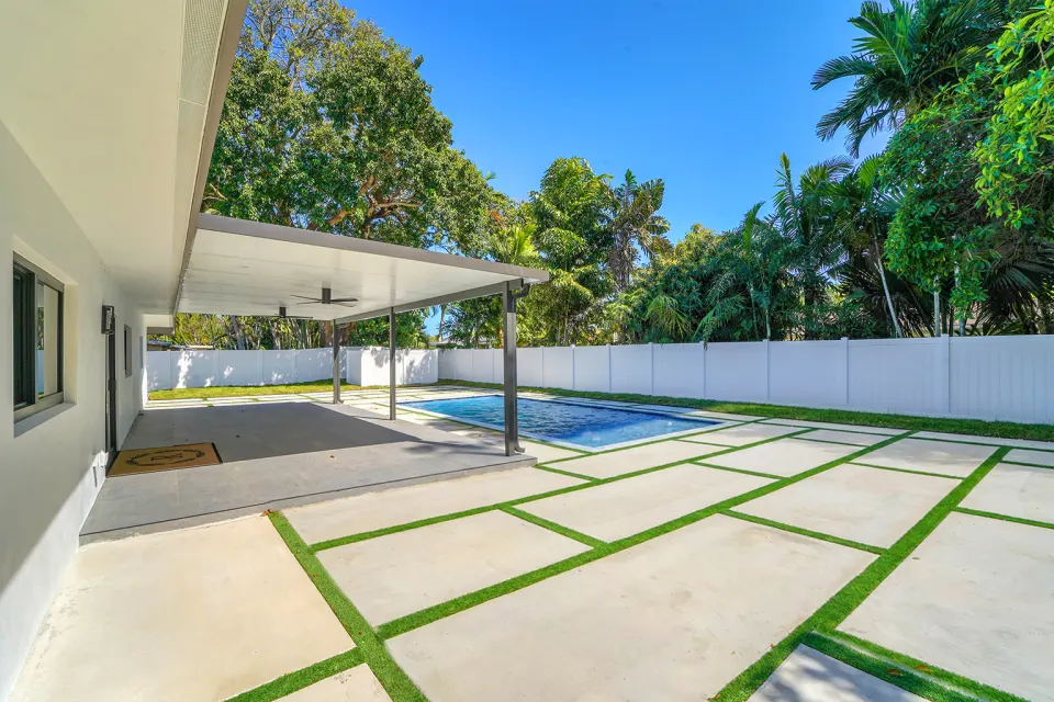 Terraza techada y piscina con adoquines